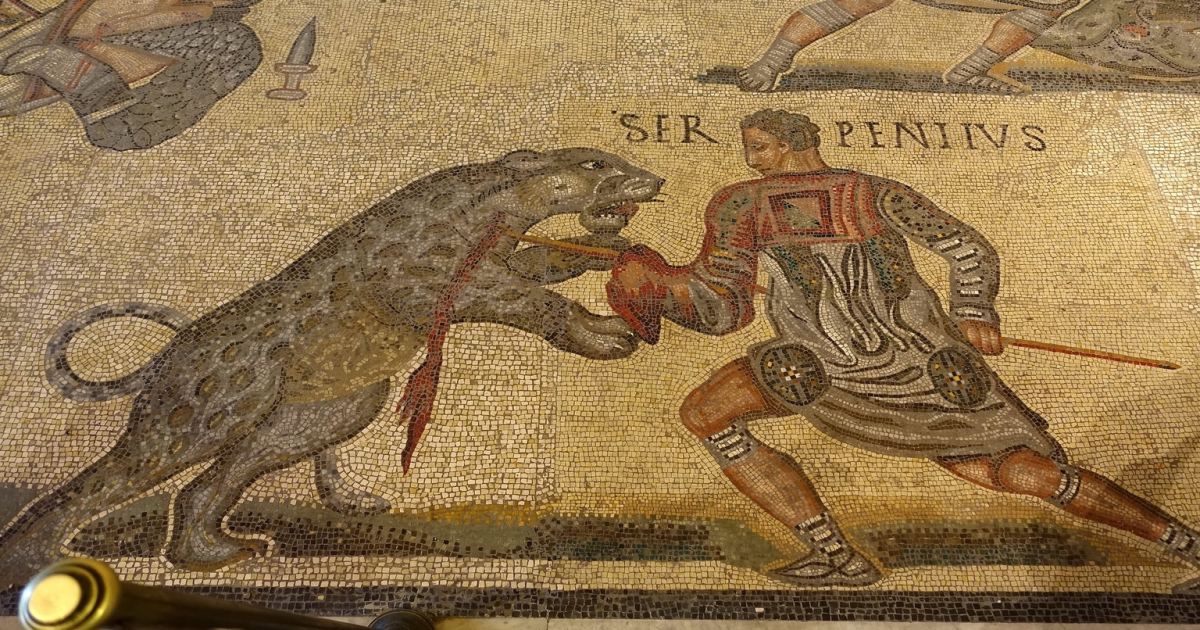 Roman mosaic depicting venationes, showing gladiators or hunters fighting wild animals in a public arena spectacle